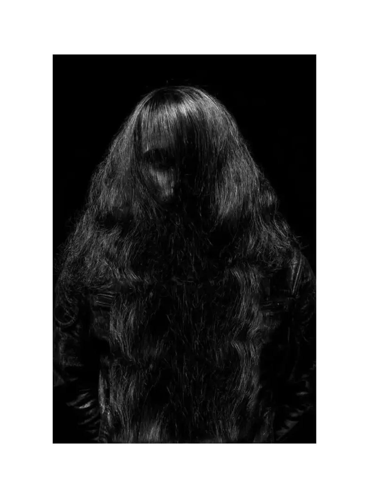 Schwarzweißportrait mit langem Haar vor dem Gesicht